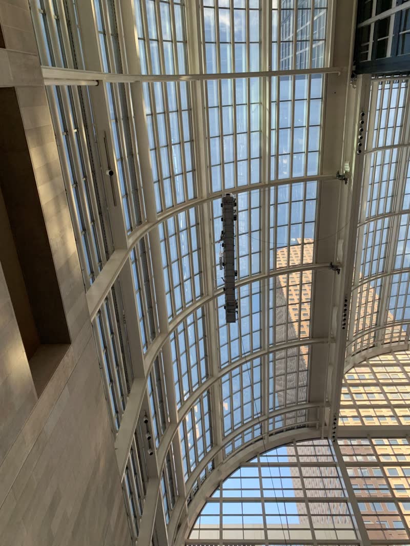 Suspended work platform inside a curved glass atrium in Denver