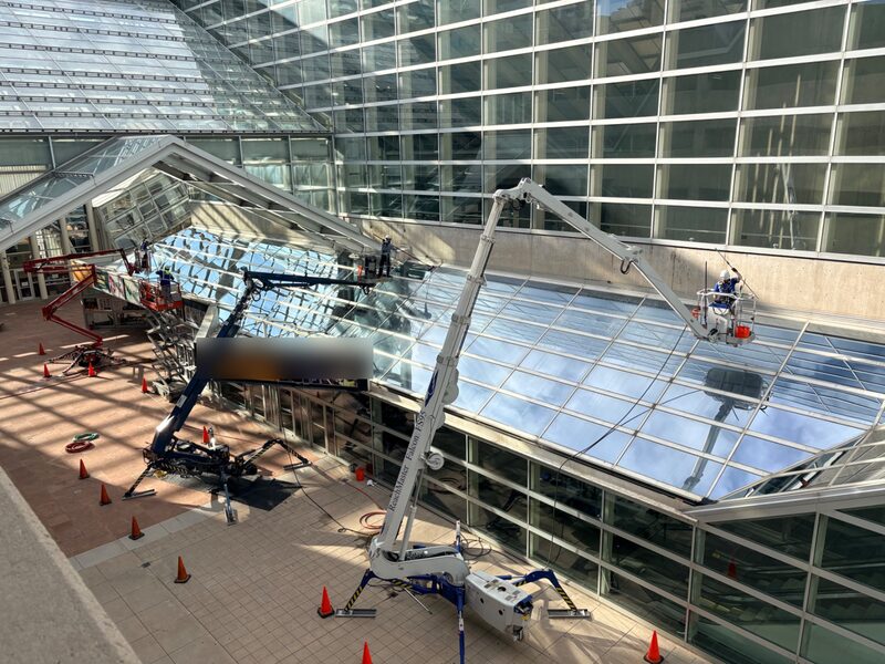 Three lifts cleaning the glass canopy of a performing arts center in Denver
