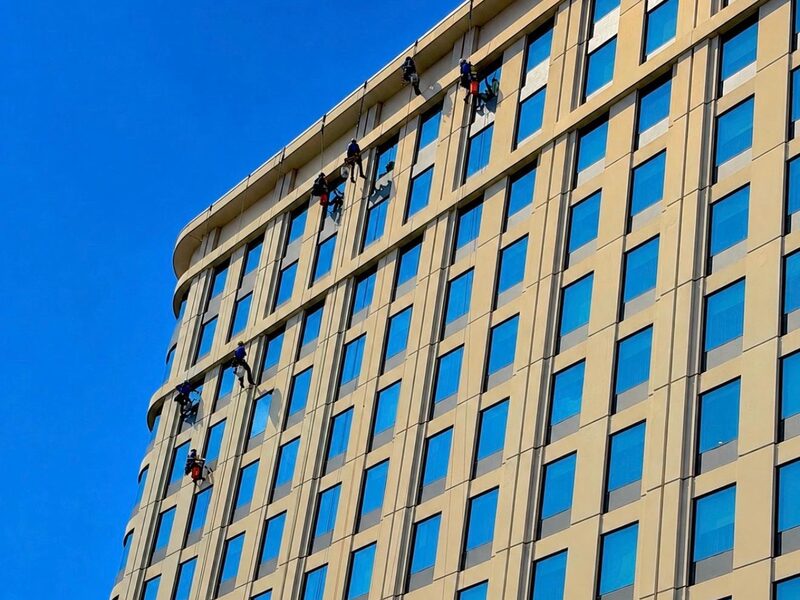 Six S&K rope technicians descending a hotel tower