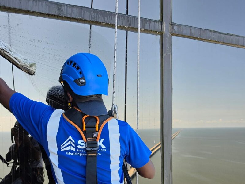 S&K technician on a bosun's chair cleaning a glass tower in New Orleans