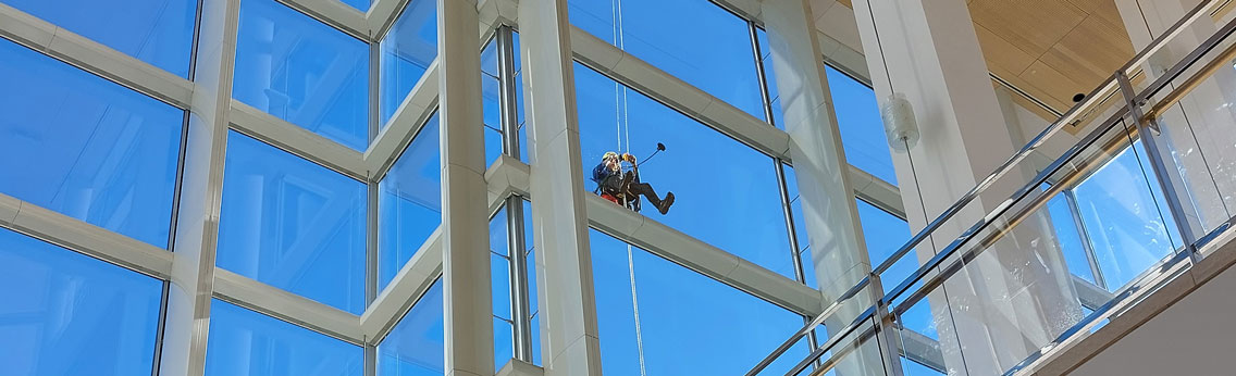 Bright commercial lobby with clean glass windows and polished floors maintained by S&K Building Services during winter.